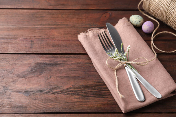 Cutlery set with quail eggs on wooden table, space for text. Easter celebration - Foto, Imagem