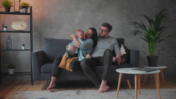 Fiatal család játszik együtt a kanapén. Boldog család. otthoni kényelem. - Felvétel, videó