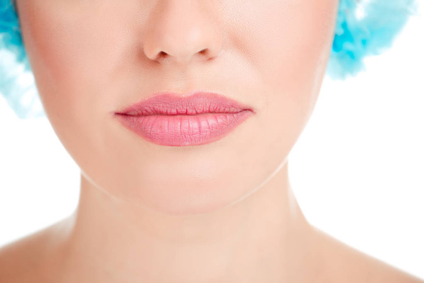 Closeup crop image of chin and lips, mouth of girl, woman in scrub cap preparing for cosmetic filler procedure, lips augmentation isolated cutout on white background. Mixed latin american caucasian - Foto, imagen