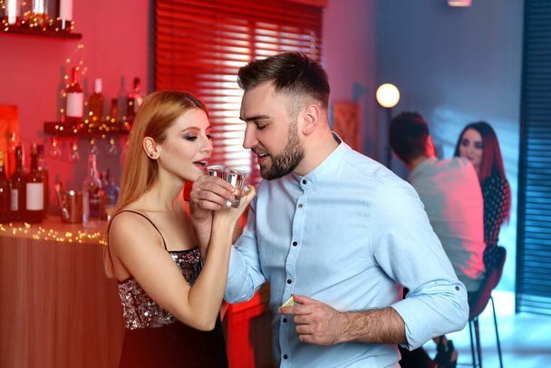 Young couple drinking Mexican Tequila shots in bar - Photo, Image
