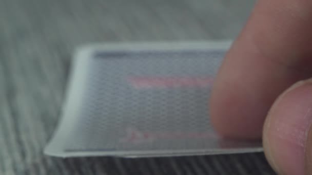 Low angle closeup view of a male hand picking up and showing cards from a casino table - Footage, Video