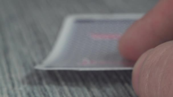 Χαμηλή γωνία closeup άποψη ενός αρσενικού χεριού μαζεύοντας και δείχνοντας κάρτες από ένα τραπέζι καζίνο - Πλάνα, βίντεο