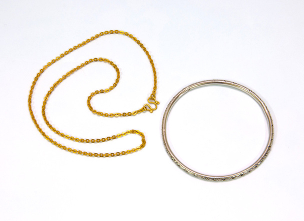 goldene Ketten und silbernes Armband isoliert auf weißem Hintergrund - Foto, Bild