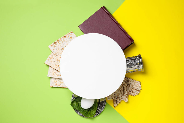 Frame made with symbolic Passover items and blank card on color background, space for text. Pesah celebration - 写真・画像