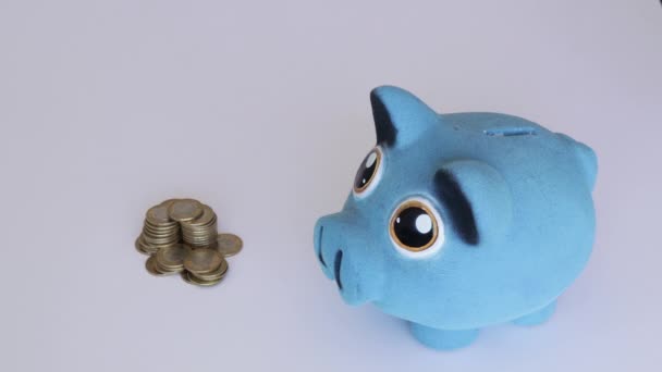 Two hands saving mexican Money on blue piggy bank - Footage, Video