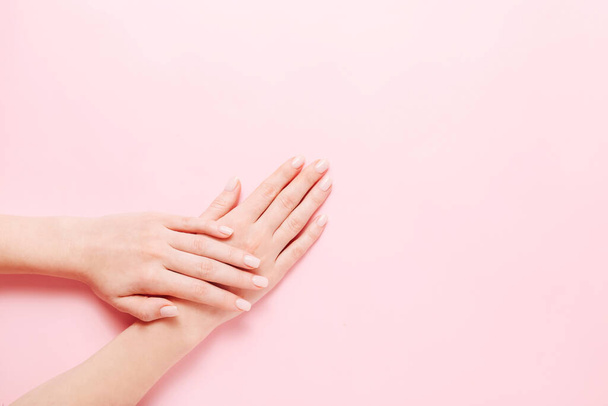Vrouwen handen met mooie manicure op roze achtergrond. Handen spa concept - Foto, afbeelding