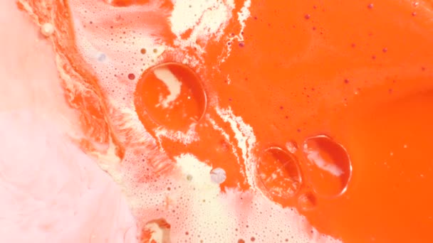 Barevné akrylové barvy se mísí do krásných vzorů. Olejové barvy korálů, oranžové, červené a jiné barvy se šíří po povrchu a mísí, vytváří úžasné textury a design. Abstraktní bubliny - Záběry, video