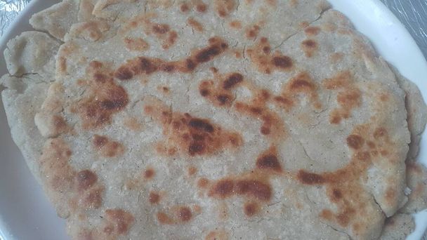 Κοντινή άποψη του παραδοσιακού ψωμιού που ονομάζεται Jawar roti ή bhakri. Bhakri είναι ένα στρογγυλό επίπεδο άζυμο ψωμί που χρησιμοποιείται συχνά στην κουζίνα πολλών ασιατικών χωρών - Φωτογραφία, εικόνα