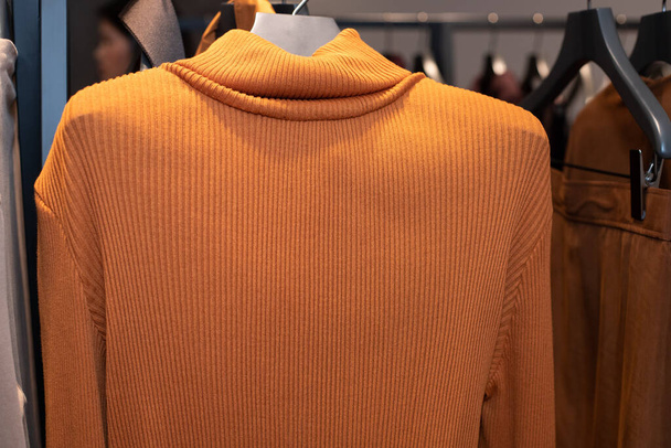 Fashion Design Clothes on Display rack in retail shop, νέα συλλογή πορτοκαλί ζιβάγκο casual φόρεμα σε παράθυρο shopping sale με stylist υπηρεσίες την άνοιξη του καλοκαιριού φθινόπωρο χειμώνα, αντίγραφο χώρου κείμενο λογότυπο - Φωτογραφία, εικόνα