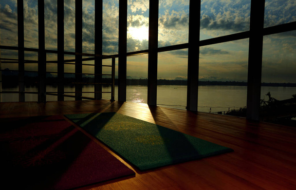 Lege houten vloer in fitnesscentrum, Uitzicht op de Grote Raammuur, moderne loft studio, ontrolde yoga mat op de vloer, comfortabele open ruimte voor sport, ontspanning, rust, meditatie en oefeningen - Foto, afbeelding