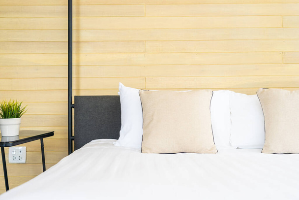 Almohada cómoda blanca en la decoración de la cama interior de la habitación en el complejo hotelero
 - Foto, imagen