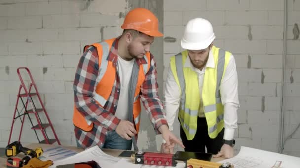 Young architects checking equipment on construction site - Filmmaterial, Video