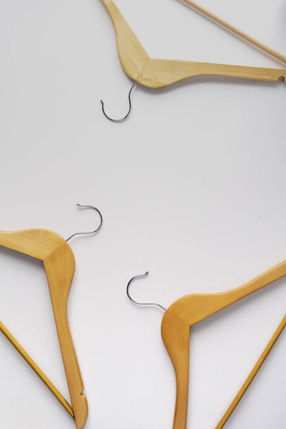 top view of abstract wooden clothes hangers flat lay on color surface - 写真・画像