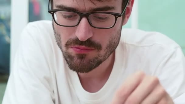 Close-up portret van een blanke man met een bril die hete thee drinkt. - Video