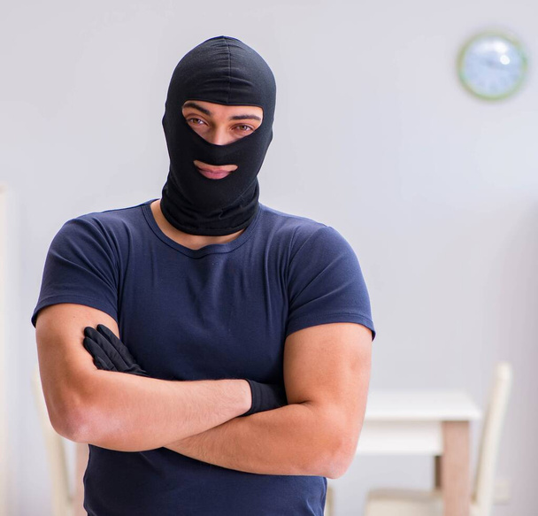 Robber wearing balaclava stealing valuable things - Photo, Image