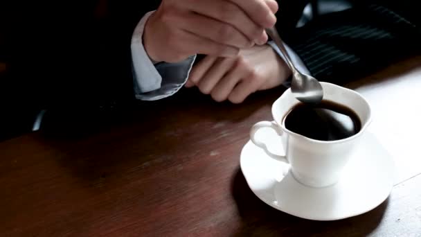Рука бізнес-леді, використовуючи ложку, щоб перемішати чашку кави
. - Кадри, відео