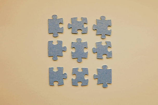 Grijze puzzels op een beige achtergrond - Foto, afbeelding