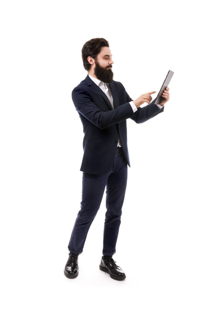 full length portrait of bearded businessman with tablet in hands, isolated on white background - Photo, Image