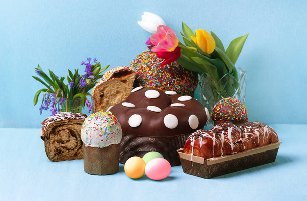 イースターケーキと春の花青い背景にイースターブレッドと卵 - 写真・画像