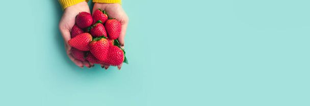 červené jahody v rukou nad modrým pozadím, letní bobule, panoramatické makety - Fotografie, Obrázek
