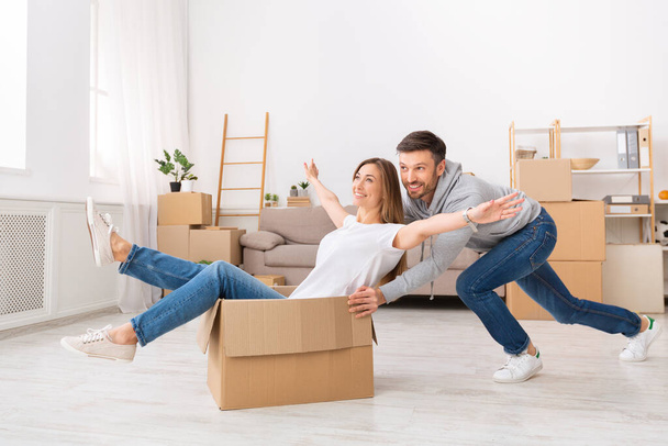 Молода пара розважається під час переїзду в нову квартиру
 - Фото, зображення