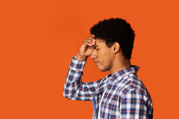 Stress, lack of inspiration or depression. African-American man thinking on color background, side view. Copy space - Fotoğraf, Görsel