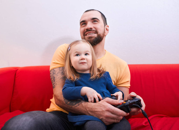 happy caucasian daughter and father play video games - Foto, imagen
