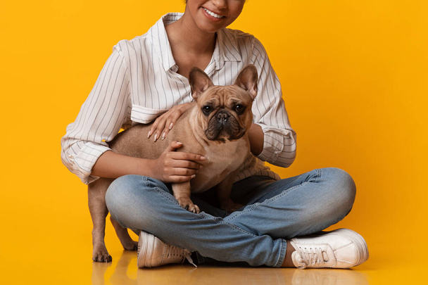 Cute French Bulldog Dog Puppy Posing With Owner, Unrecognizable Black Woman - Foto, immagini