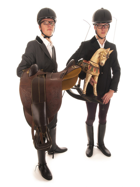 Two handsome young men with horses outfit and a rocking horse - 写真・画像