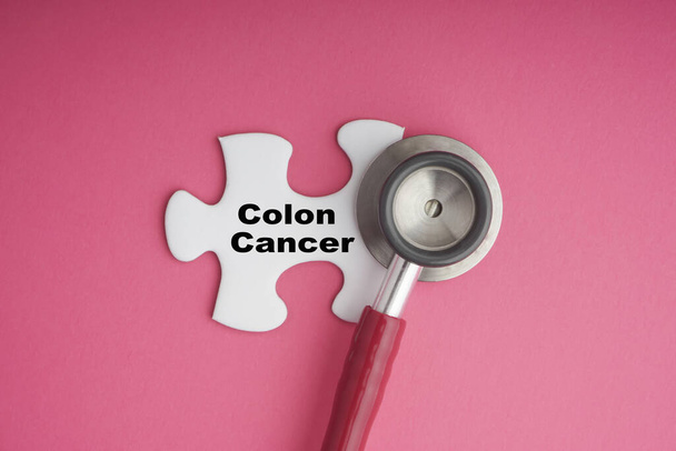 COLON CANCER texte avec stéthoscope sur puzzle blanc sur fond rose. Concept de campagne de sensibilisation au cancer
 - Photo, image