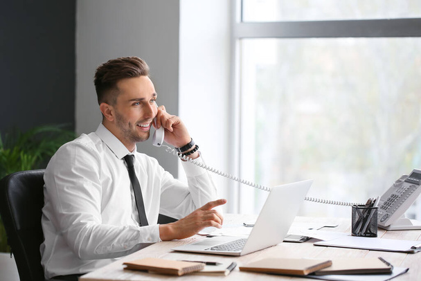 Happy businessman talking by telephone in office - Photo, Image