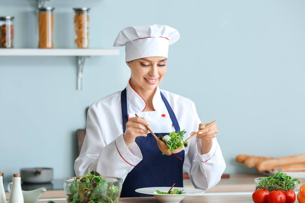 Chef feminino fazendo salada fresca na cozinha
 - Foto, Imagem