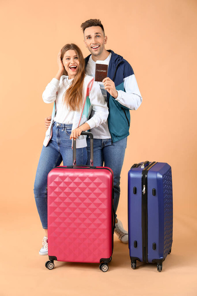 Couple of young tourists with luggage on color background - Photo, Image