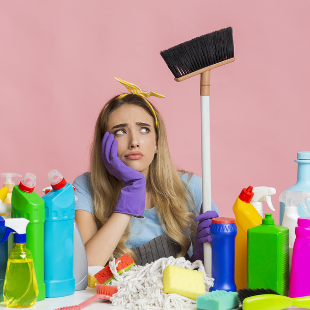 Household chores. Thoughtful girl holding a mop - Foto, afbeelding