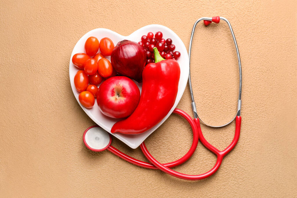 Тарелка со здоровыми продуктами и стетоскопом на цветном фоне
 - Фото, изображение