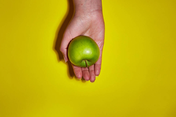 Lemon in hand on yellow background. Flat lay, top view, copy space . Food dietary concept. - 写真・画像