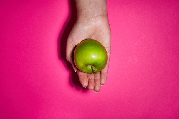 Lemon in hand on pink background. Flat lay, top view, copy space . Food dietary concept. - Fotó, kép