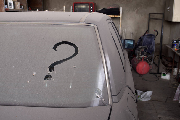 Un punto interrogativo sul finestrino di un'auto sporca e non lavata
. - Foto, immagini