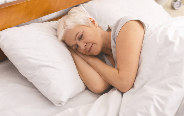 Senior lady sleeping in bed in morning, panorama - Photo, Image