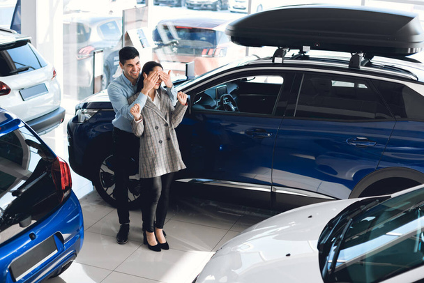 Aviomies peittää vaimot silmät Näytetään uusi auto autokaupassa
 - Valokuva, kuva