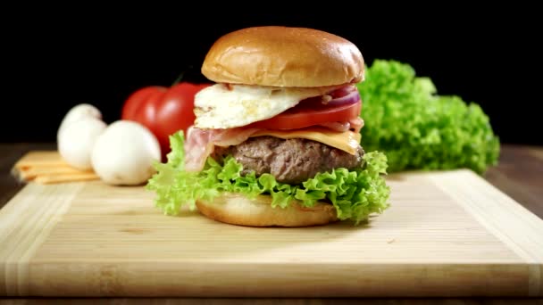 Gotowane duży burger z kotletem mięsnym i warzywami. - Materiał filmowy, wideo