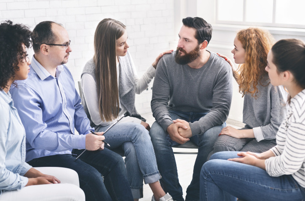 Therapy Group Members Comforting Upset Man On Community Meeting In Rehab - Photo, Image