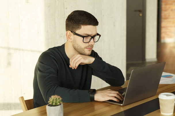 Gestionnaire de bureau Homme travaillant sur ordinateur portable assis sur le lieu de travail
 - Photo, image
