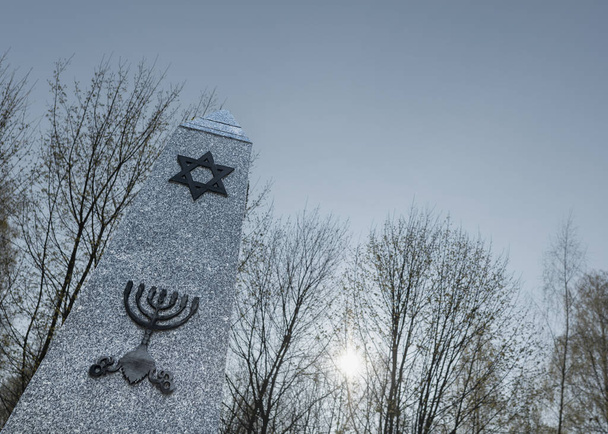 Каменный памятник с еврейской звездой и подсвечником, Польша
 - Фото, изображение