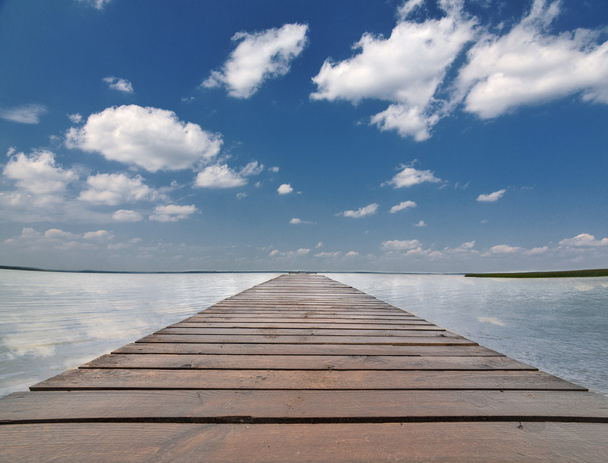 muelle de madera en gran lago bajo cielo azul
 - Foto, imagen