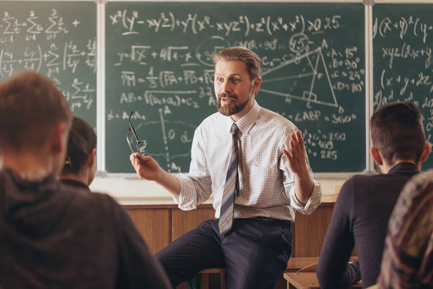 Энтузиастичный учитель математики, держащий урок
 - Фото, изображение