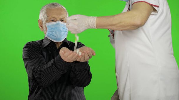Hombre mayor con máscara de protección médica. El doctor da pastillas. Coronavirus
 - Foto, imagen