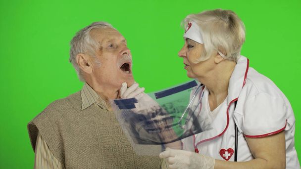 Зрелая медсестра врач осматривает пожилого пациента мужчина с проблемами
 - Фото, изображение