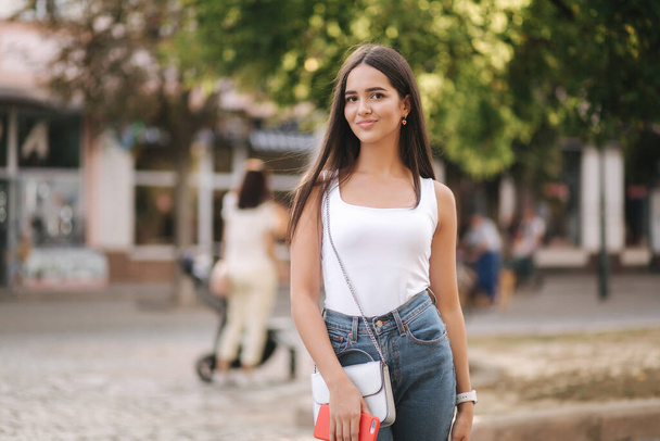 Attrayant jeune femme marchant dans le centre de la ville en été. Belle brune en chemise blanche. Souriez.
 - Photo, image