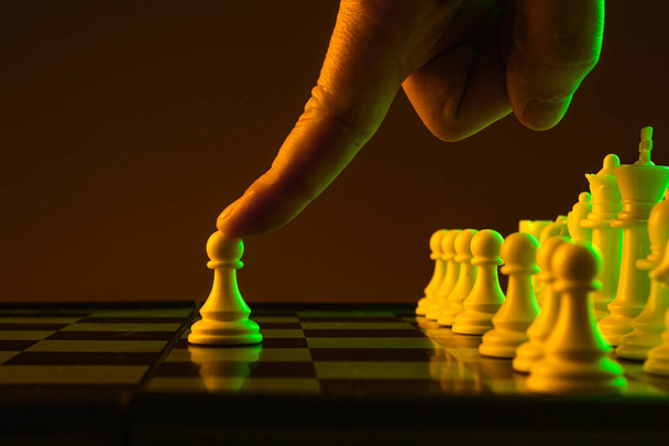 Close-up hand maakt een pion zet, schaken, schaakbord, spel, confrontatie - Foto, afbeelding